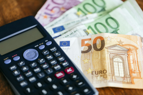 Rekenmachine en eurobiljetten op een tafel