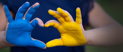 Gelb-blaue Hand formt Herz