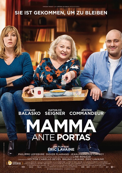 The mother sits on the sofa with a tray of supper on her knees and smiles at the remote control. Next to her on one side is her daughter with folded arms and a slightly resigned look. On the other side sits the son-in-law with an embarrassed smile.