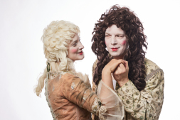  Man and woman in costumes and wigs looking at each other  