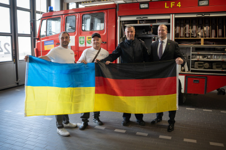 Together (from right) First City Councillor Björn Volmering and Robert Liebrand from the Bocholt fire brigade hand over the emergency vehicle to Oleksandr Shyshkin and Yurii Yakubovskyi from the Yellow Cross Association.