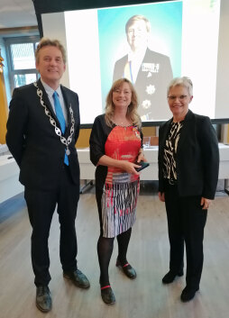  Anton Stapelkamp, Mayor of the municipality of Aalten, honours Gerda Brethouwer (centre), Director of the National Onderduikmuseum Aalten, with the Dutch Order of Merit \