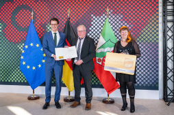  Ministerpräsident Hendrik Wüst (links) überreicht gemeinsam mit Staatssekretärin Andrea Milz die Jubiläums-Ehrenamtskarte an Leo Engenhorst. 