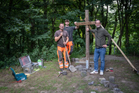 Hans-Jürgen Büdding (von links) und Luis Morey Vazquez vom Entsorgungs- und Servicebetrieb haben das Kreuz, das der Bocholter Pierre Martin (rechts) gemeinsam mit seinen Freunden gebaut hat, jetzt standsicher befestigt.