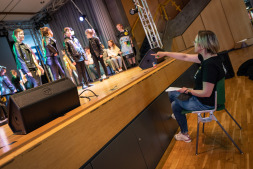  Musikschullehrerin Stefanie Bergmann (rechts) probt mit den Teilnehmerinnen und Teilnehmern die Abläufe auf der Bühne. 