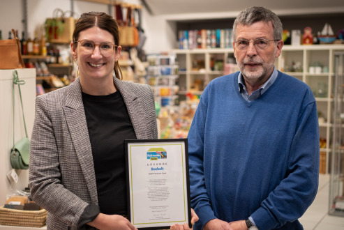 Jana Tüshaus vom Büro des Bürgermeisters überreicht die Urkunde an Siegfried Löckener vom Arbeitskreis Eine Welt Bocholt e.V.