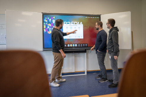 Marc Straubel (von links), Simon Wehren und Nils Jordan vom Fachbereich Digitales und IT richten eine der neuen Tafeln ein. 