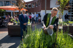  Pfarrer Rafael van Straelen von der Pfarrei Liebfrauen segnet die neue Grünfläche ein und begießt die neu bepflanzten Beete mit geweihtem Wasser. 