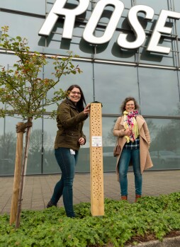  Annika Hetzert (rechts) und Anja Radermacher stehen neben dem neuen Insektenhotel des Unternehmens Rose. 