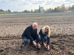 Locoburgemeester Kerstin Erkens en Wethouder Erik Groters planten bloembollen op de grens