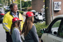 Polizeihauptkommissar Michael Schneider hilft den Kindern, die Autofahrer anzusprechen Polizeihauptkommissar Michael Schneider hilft den Kindern, die Autofahrer anzusprechen