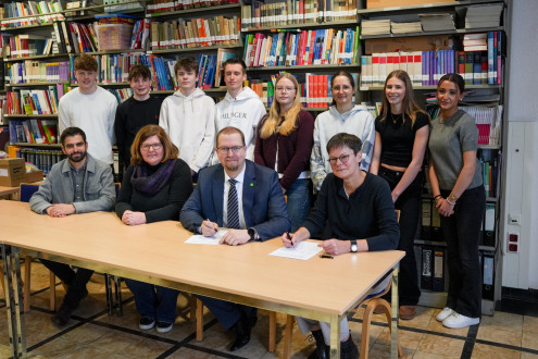 In aanwezigheid van de leerlingen ondertekenden Oliver Brenn (vanaf links) (afdeling Cultuur en Archief), geschiedenisleraar Dominique Ischinsky, gemeenteraadslid Björn Volmering en directrice Hilke Smidt de samenwerkingsovereenkomst.
