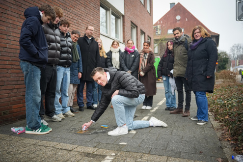 Leerlingen van St George's Grammar School maken samen de struikelstenen van Max en Paul Hochheimer in de Weberstraße schoon.