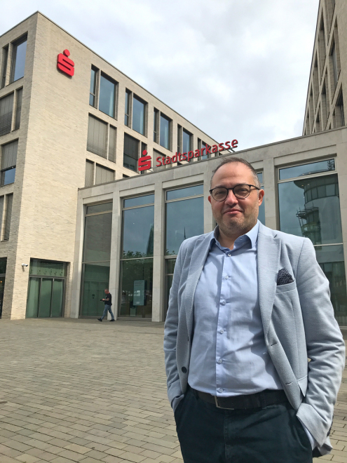 Gültekin Izgi vor seiner Arbeitsstelle, der Hauptstelle der Stadtsparkasse Bocholt - Foto: Bruno Wansing Gültekin Izgi vor seiner Arbeitsstelle, der Hauptstelle der Stadtsparkasse Bocholt - Foto: Bruno Wansing